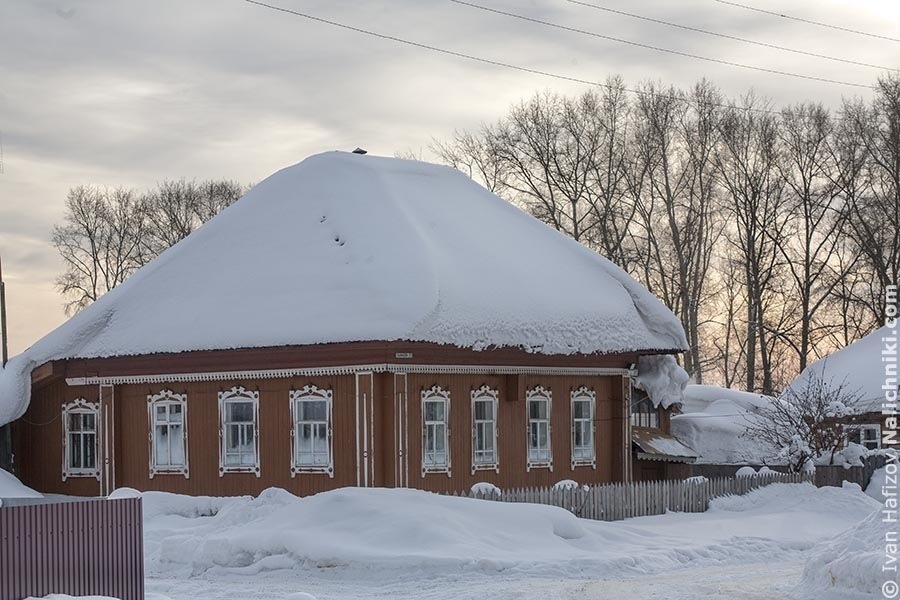Зимний городской пейзаж: традиционный деревянный одноэтажный дом 