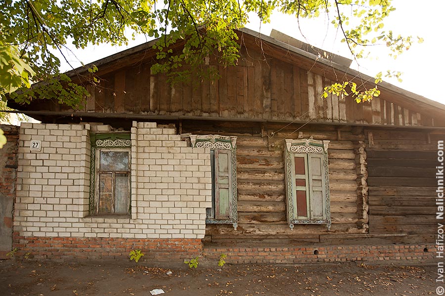 Дом с деревянными наличниками, который закрывают кирпичем