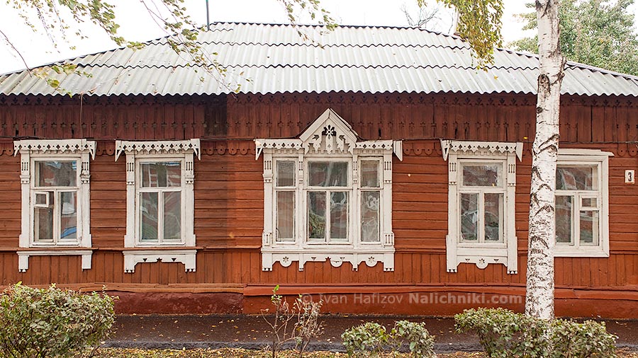 Деревянный дом с наличниками на окнах